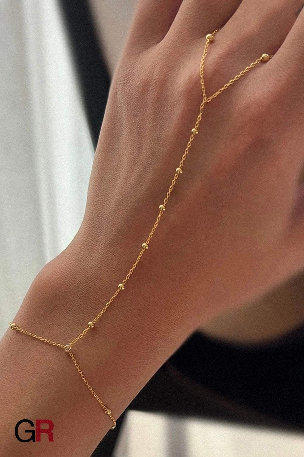 “GlamoROZ Voile Dore Luminous Gold Beaded Hand Chain Jewelry front view on neutral background”