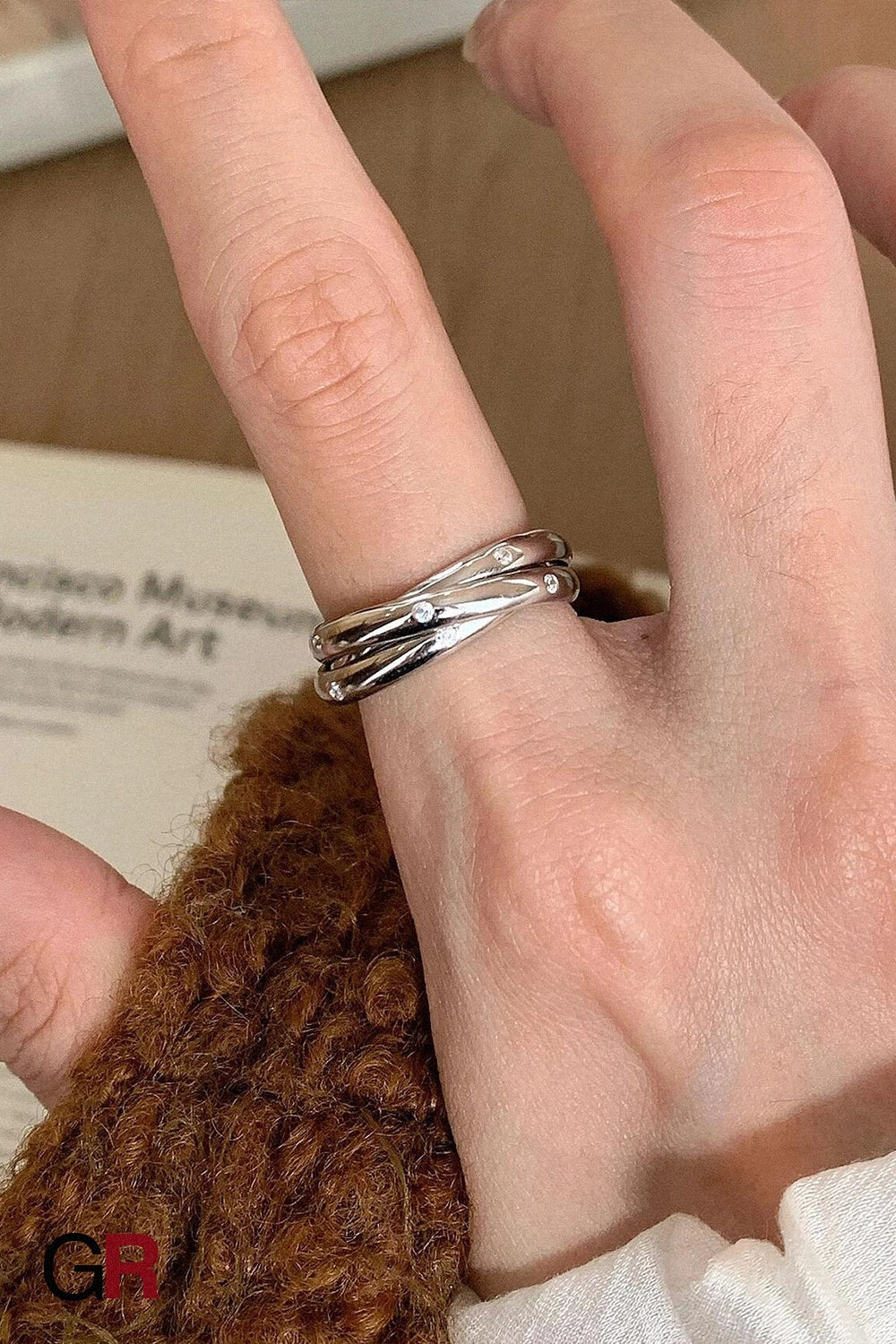 “GlamoROZ Éclat Entrelacé Silver Multi-Layer Trinity Ring Jewelry front view on neutral background”