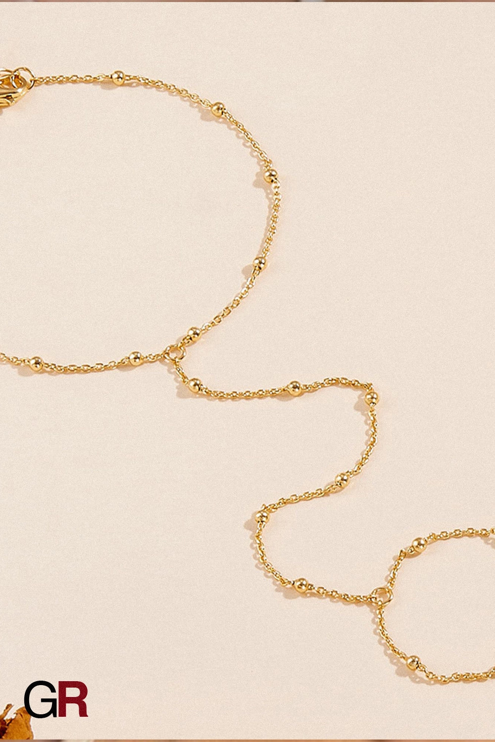 “GlamoROZ Voile Dore Luminous Gold Beaded Hand Chain Jewelry close-up showing gold beads and chain detail”