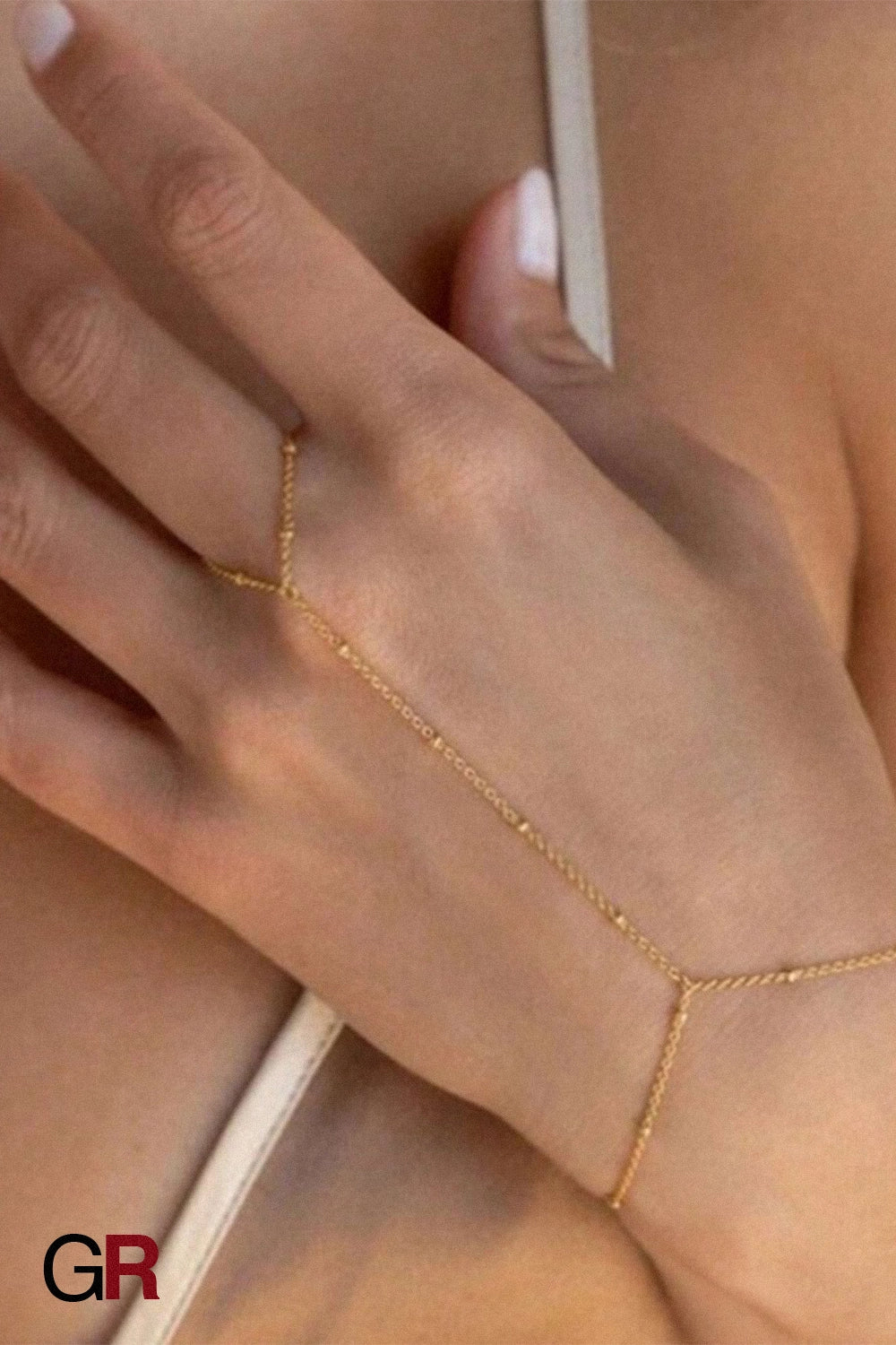 “GlamoROZ Voile Dore Luminous Gold Beaded Hand Chain Jewelry styled on model hand”