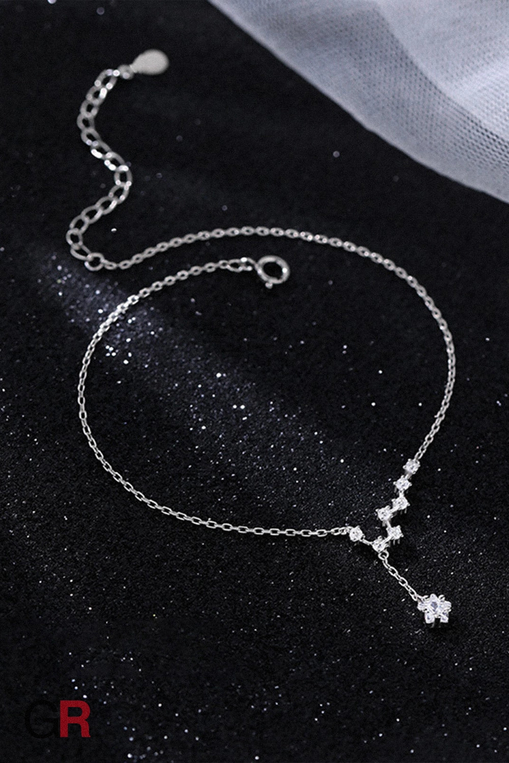 “GlamoROZ Éclat Argenté Luminous Silver Anklet Jewelry flat-lay on light grey fabric background”