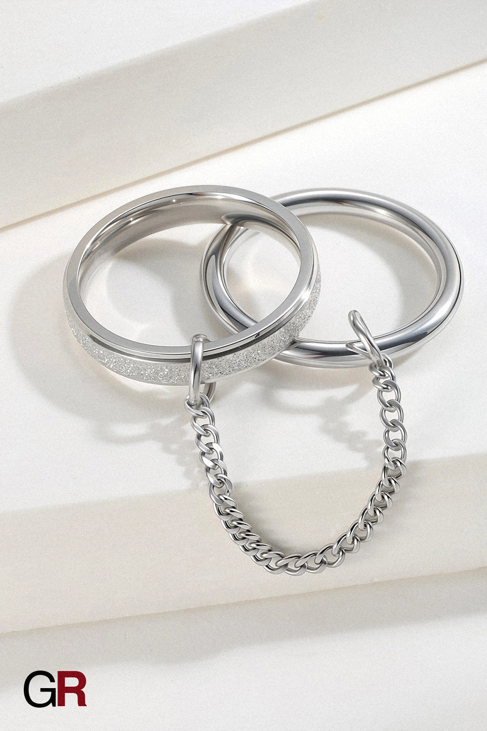 “GlamoROZ Orbit Duo Gold & Silver Chain Ring Jewelry flat-lay on soft beige fabric background”