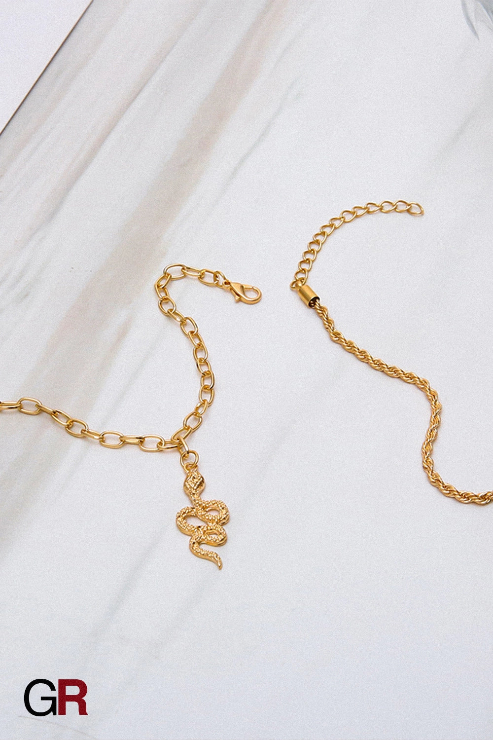 “GlamoROZ Serpentine Divine Luminous Gold Circle Anklet Jewelry flat-lay on soft beige fabric background”