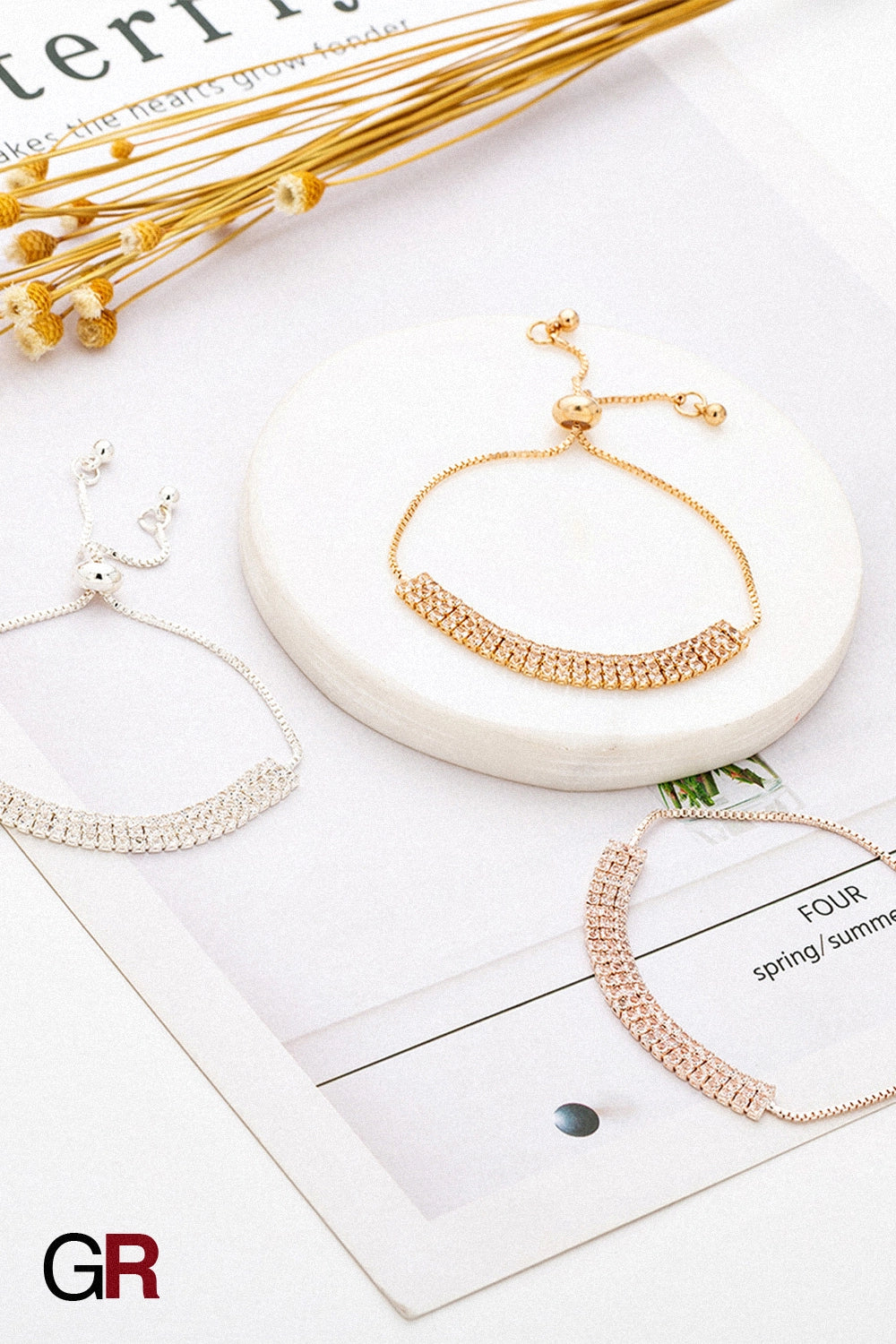 “GlamoROZ Lumiere Pavé Luminous Crystal Link Bracelet Jewelry flat-lay on soft beige fabric background”