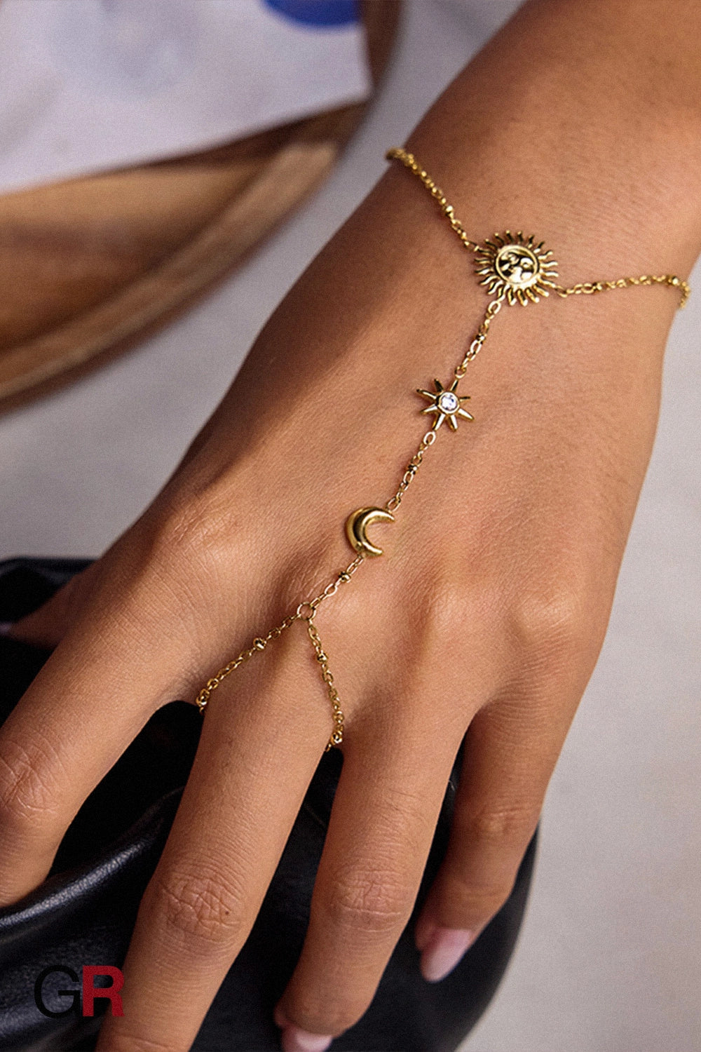 “GlamoROZ Soluna Dorée Luminous Gold Hand Chain Jewelry flat-lay on soft beige fabric background”