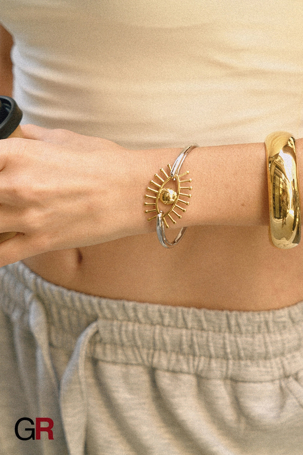 “GlamoROZ Flux Dual Luminous Silver & Gold Eye Cuff Jewelry flat-lay on soft beige fabric background”