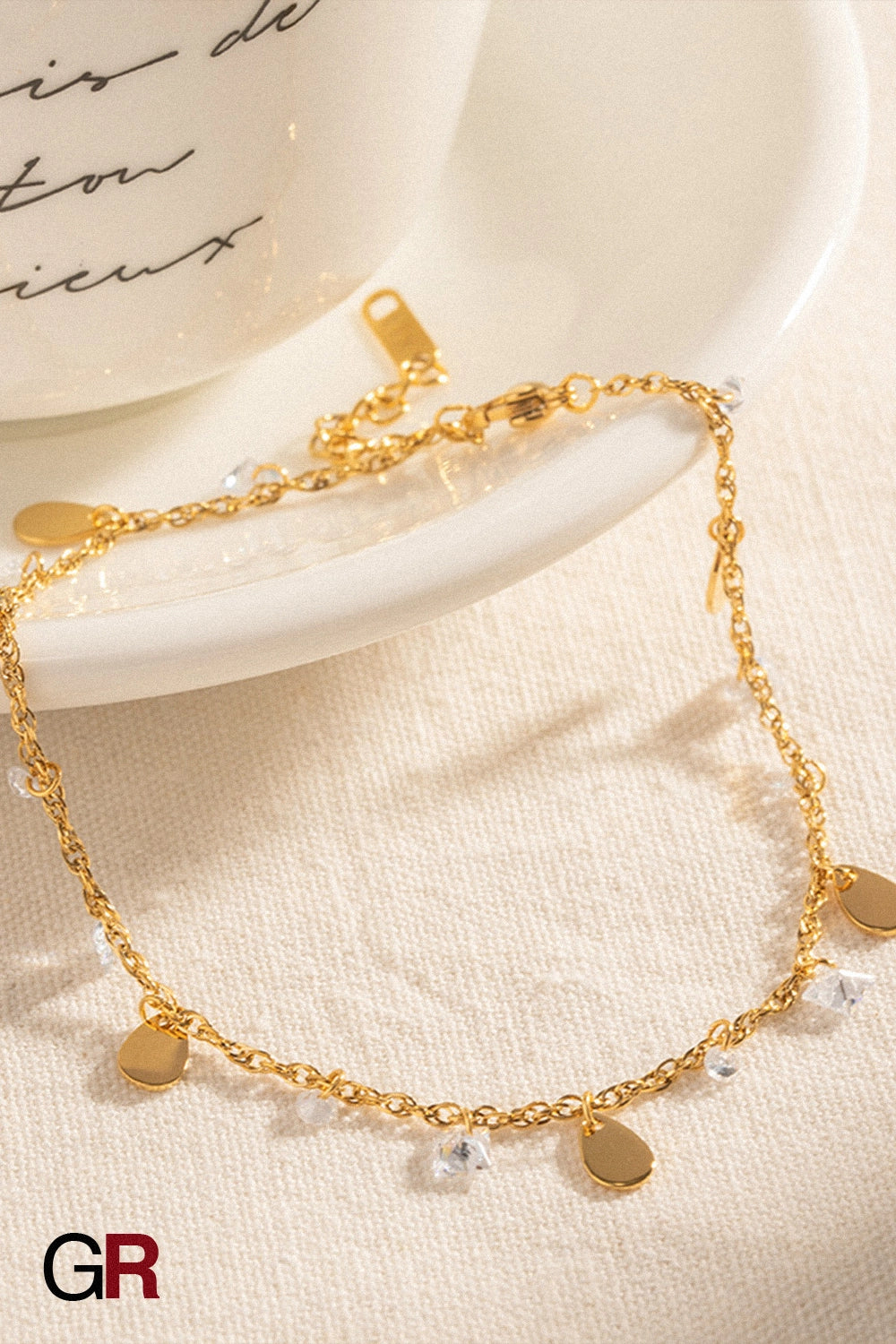 “GlamoROZ Éclat Doré Luminous Tassel Anklet close-up showing golden tassel detail”