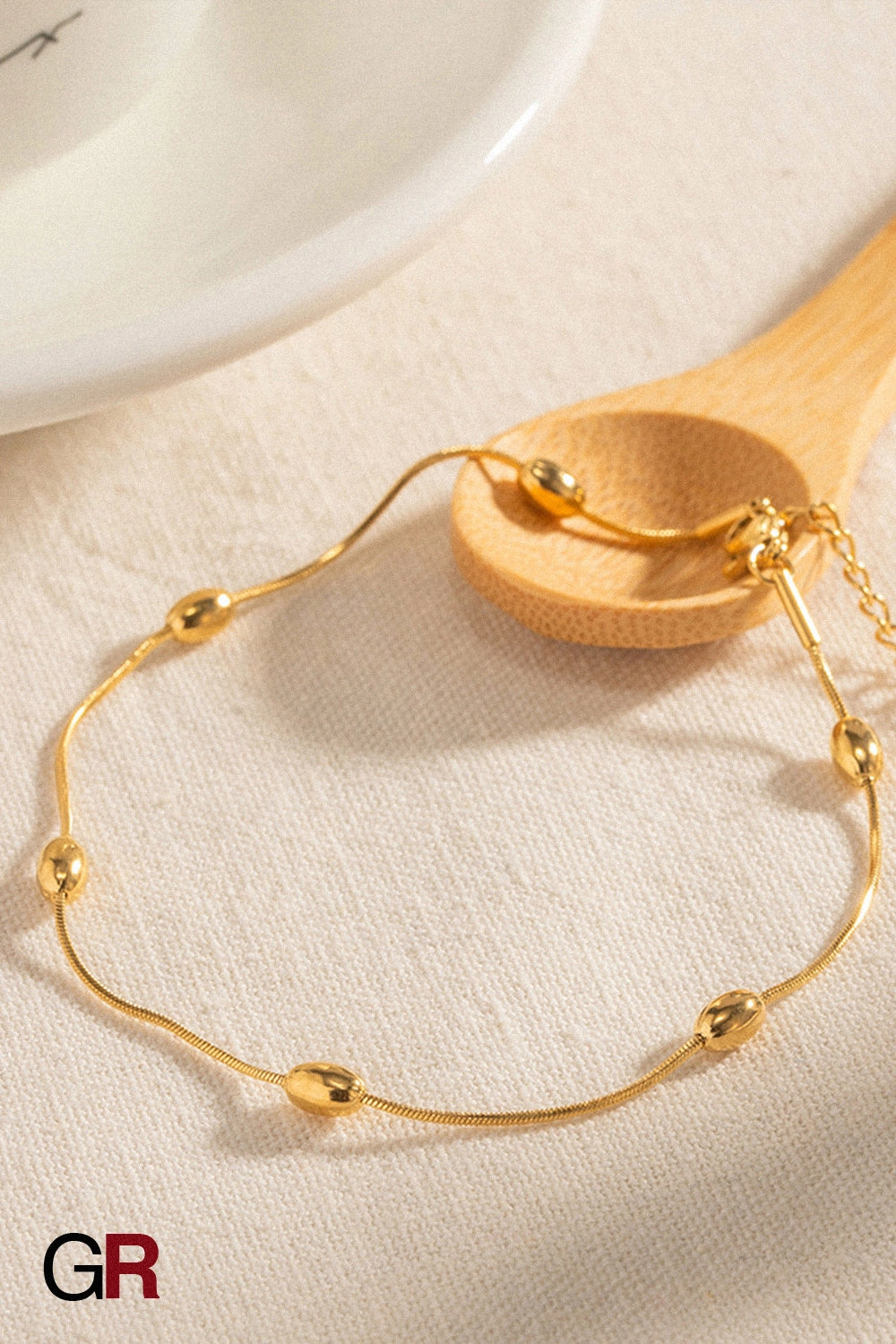 “GlamoROZ Aurora Sol Luminous Beaded Anklet styled on model ankle with sandals”