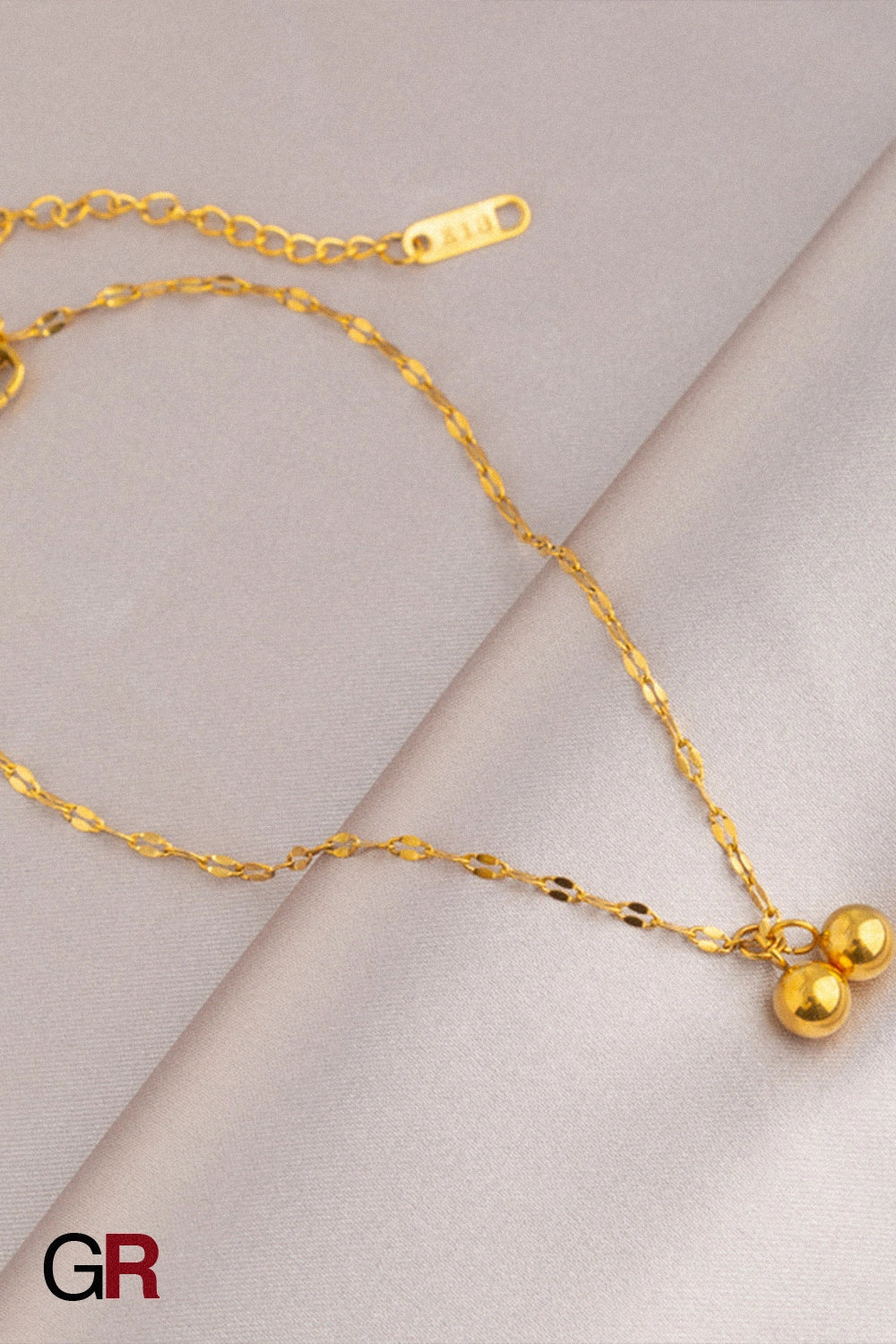 “GlamoROZ Muse Dorée Luminous Gold Beaded Anklet Jewelry flat-lay on soft beige fabric background”