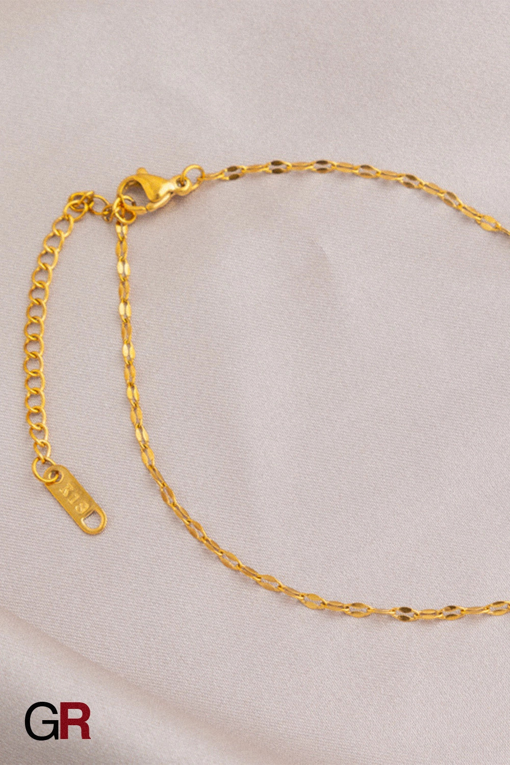 “GlamoROZ Muse Dorée Luminous Gold Beaded Anklet Jewelry flat-lay on soft beige fabric background”