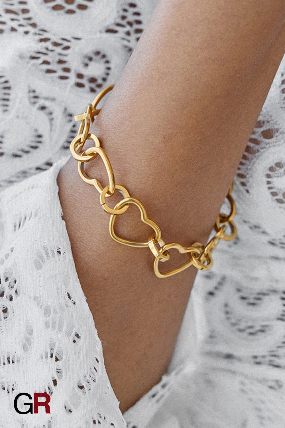 “GlamoROZ Coeur Divin Luminous Gold Charm Bracelet Jewelry styled on model wrist with elegant outfit”