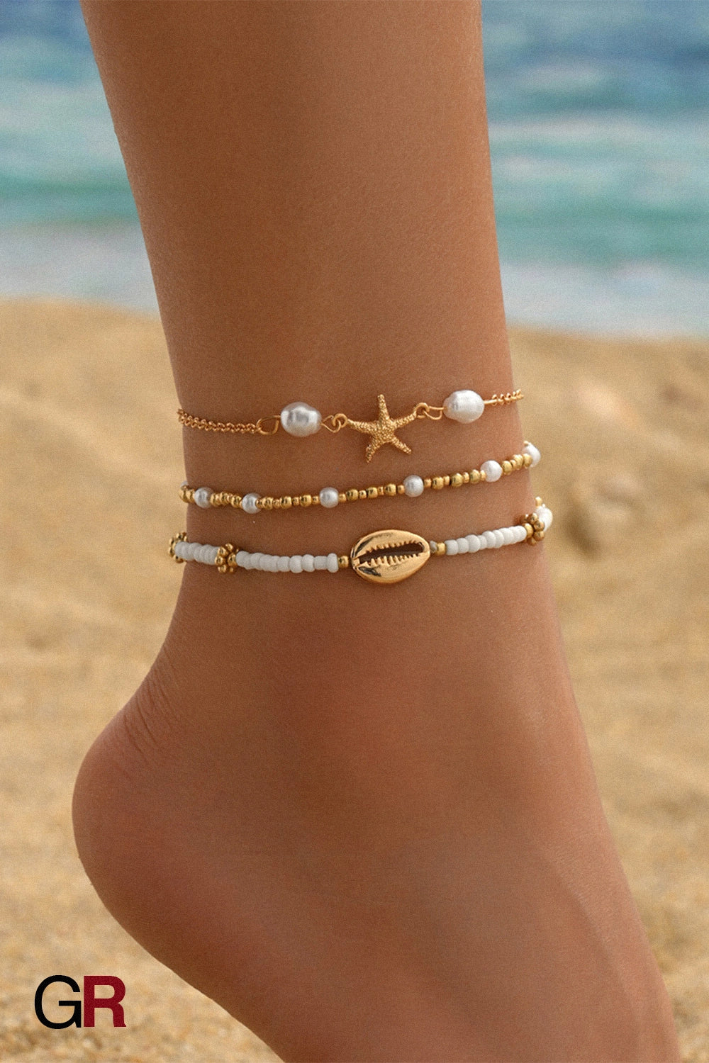“GlamoROZ Étoile de Mer Layered Anklet Set layered on model ankle beach styling”