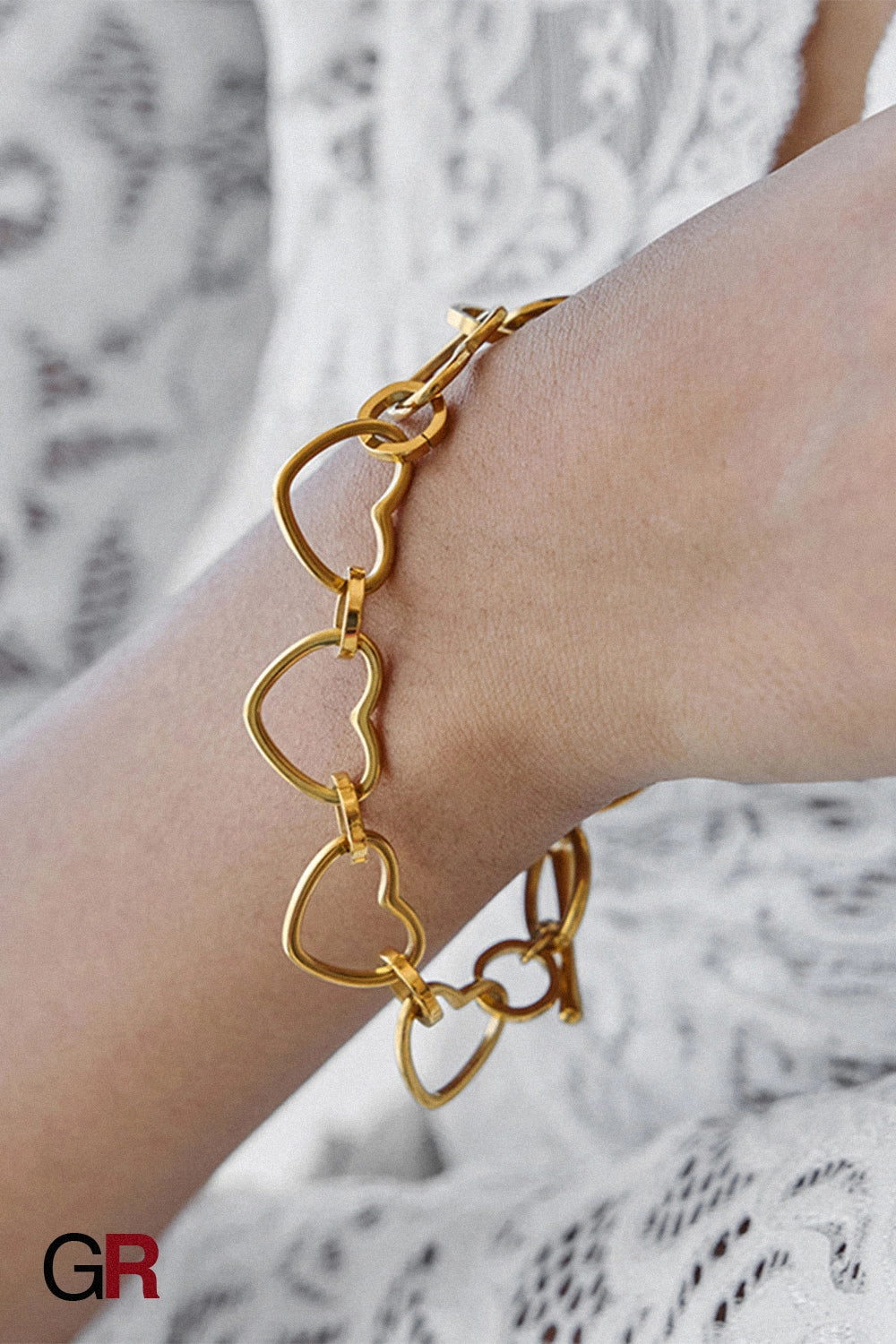 “GlamoROZ Coeur Divin Luminous Gold Charm Bracelet Jewelry front view on neutral background”