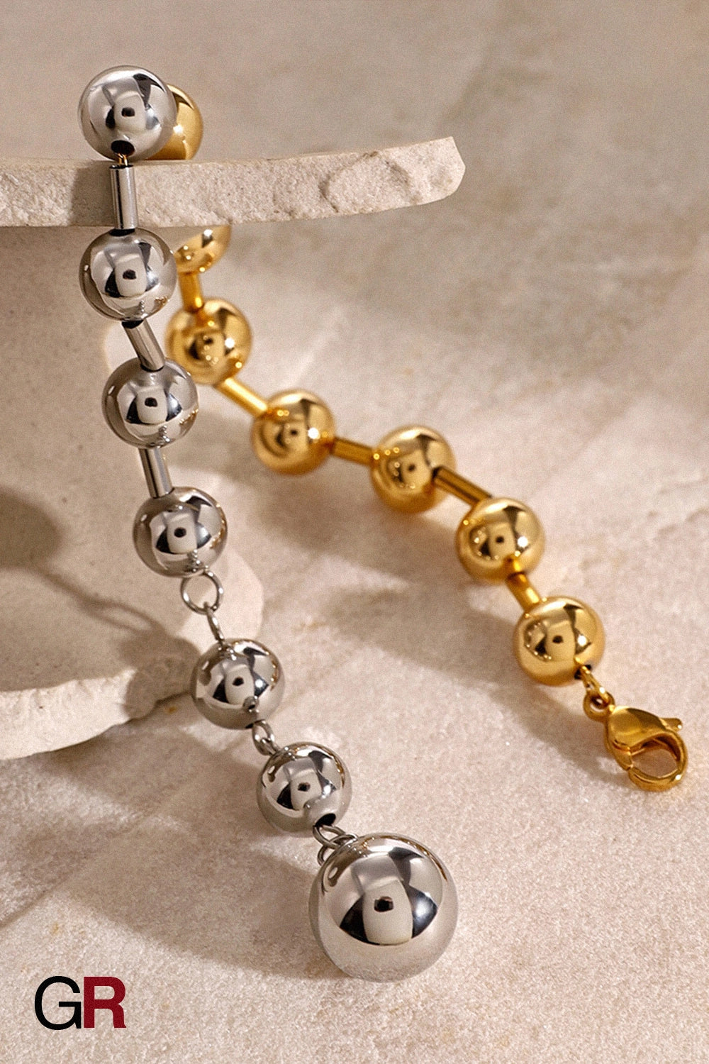 “GlamoROZ Éclat Doré Luminous Gold Bead Bracelet Jewelry flat-lay on soft beige fabric background”